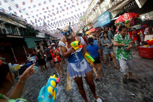A reveller uses a water gun as he participates in a water fight during the Songkran Festival celebration at Khaosan road in Bangkok
