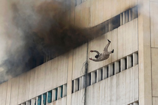 A man falls from the high floor of a burning building in central Lahore