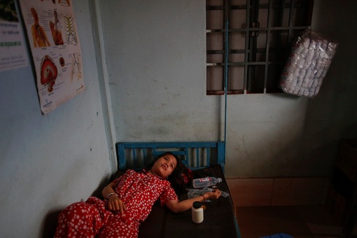 Eng Chen, a 23 year old garment worker waits to receive an intravenous therapy at an one-bed private clinic in one of Phnom Penh's suburbs