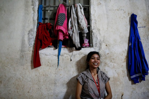 Maen Sopeak, a garment worker who shares a single room with six other girls smile during a lunch break in one of Phnom Penh's suburbs